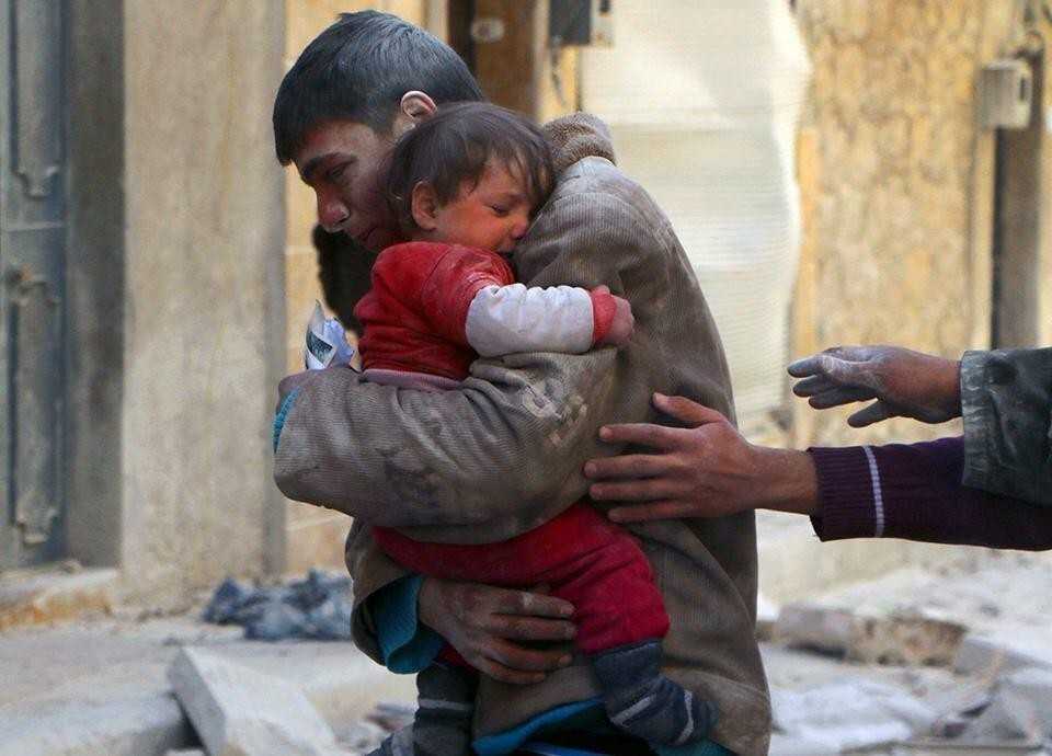 2. Chłоpak ratuje swoją siostrę spod gruzów ich domu w Syrii.