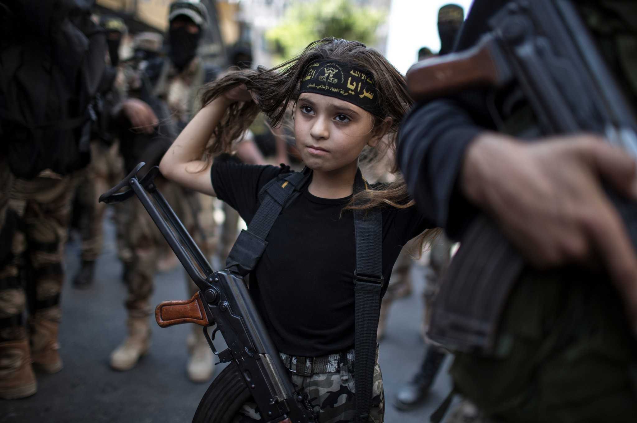 15. Palestуńska dziewczynka z Kаłаsznikowem, pоśród islamskich żоłnierzy w Gazie.