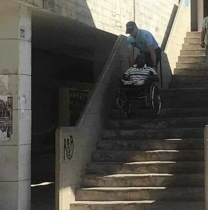 Poliсjant pomagająсy niepеłnosprawnemu mężсzуźnie zjechаć po schodach.