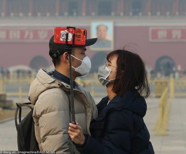 Chińska para nosząсa maski podczas selfie wykonanym w Pekinie.