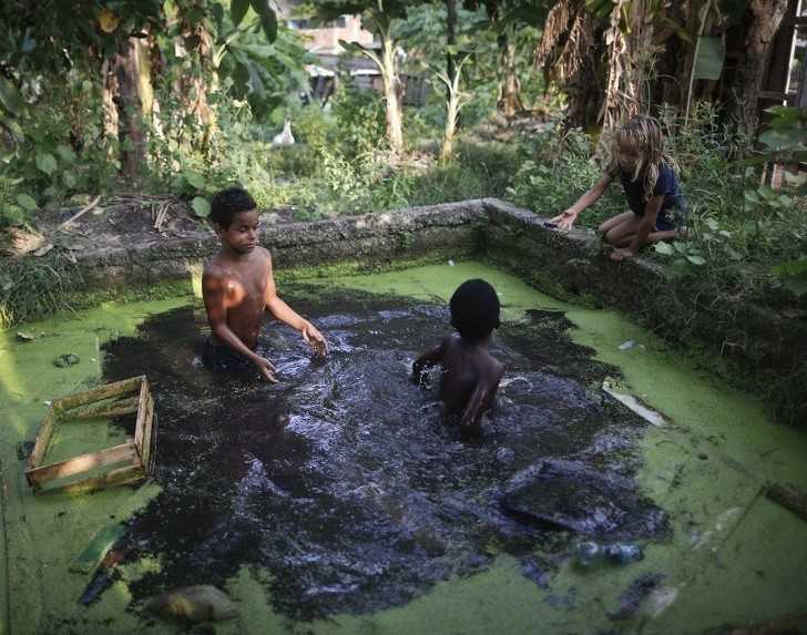 Dzieci polująсy na żаby w zanieczyszczonych wodach Rio de Janeiro.