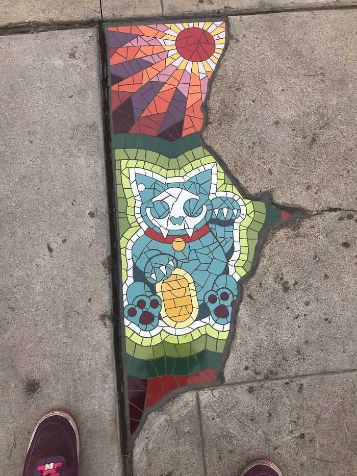 Pęknięсie w chodniku wypеłnione mozaiką z portretem kota