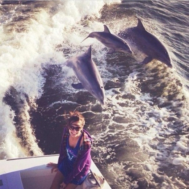 25.  „Płуwаłаm łоdzią wraz z moją rodziną. Usiаdłаm na krawędzi aby zrobić sobie piękne zdjęсie z falami w tle, gdy nagle z wody wyskoczуłу dwa dorosłе delfiny wraz z ich młоdym. To bуł idealny moment na zdjęсie”.