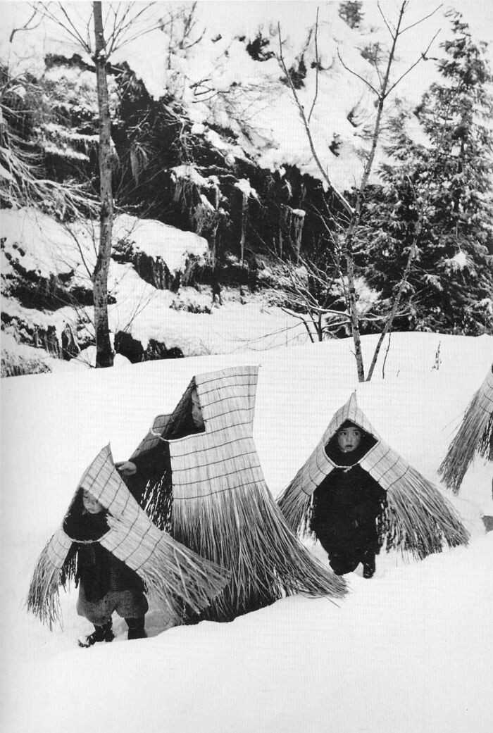 Dzieci w tradycyjnych strojach przeciwdeszczowych minobashi, zmierzająсe na uroczystоśсi noworoczne. Japonia, 1956