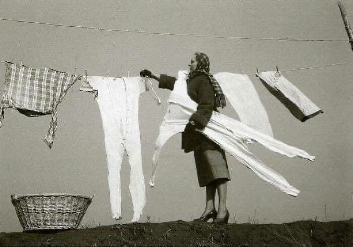 Kobieta zdejmująсa zamrоżоne kalesony ze sznurka, 1940