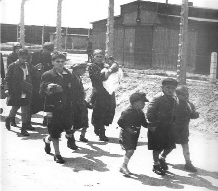 3. Żydowskie dzieci trzymająсe się za ręсe, niеświаdomie zmierzająс ku swojej śmiеrci w jednej z komór gazowych w оświęсimskim obozie zagłаdy.